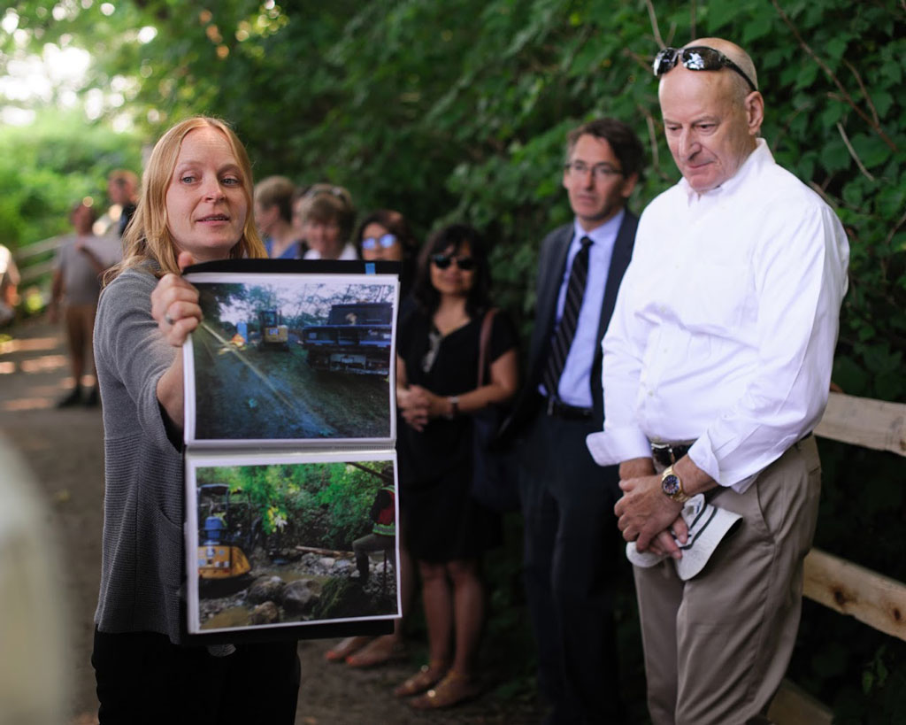 大温哥华的一位生物学家举着一张萨利希河修复不同阶段的照片。